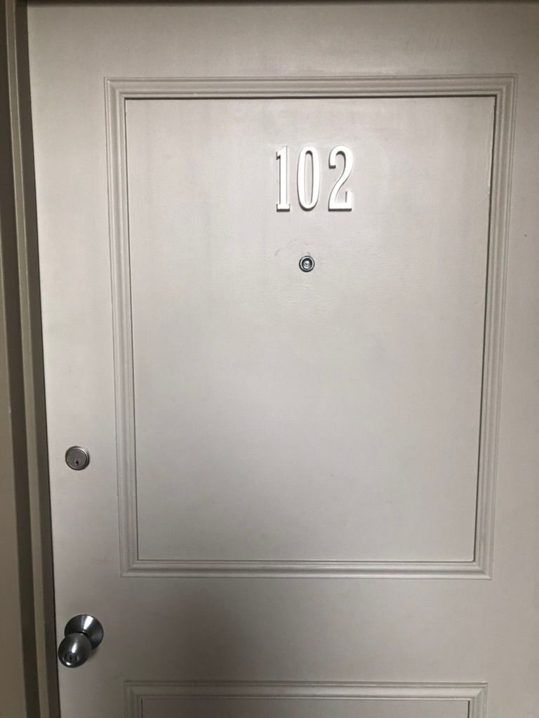 A white door with the number 102 on it.