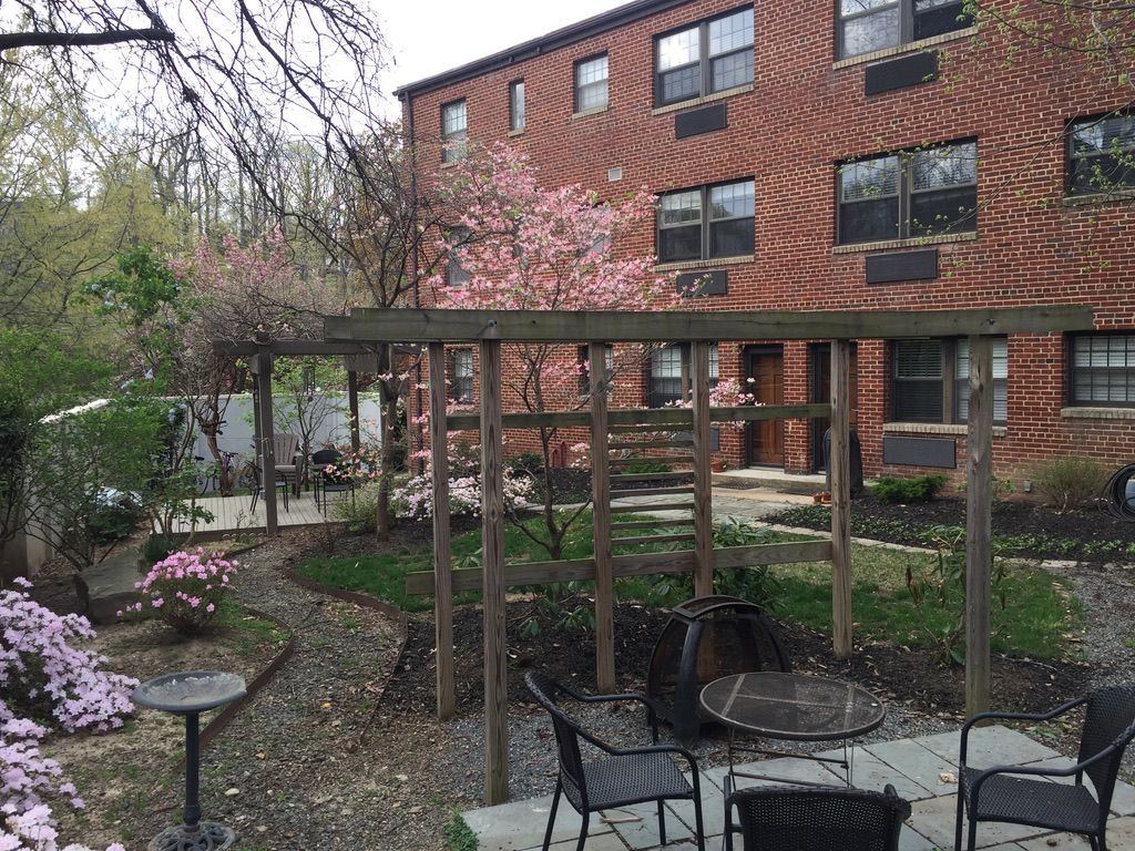 A brick building with a pergola in front of it