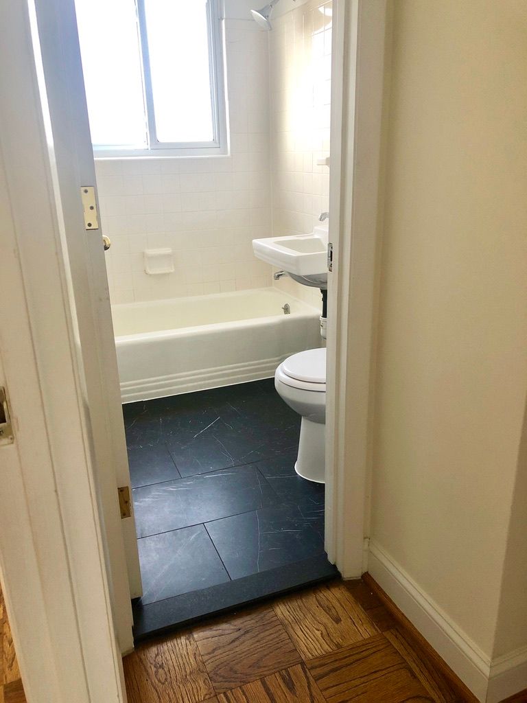 A bathroom with a toilet , sink and bathtub.