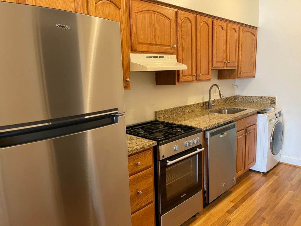 A kitchen with stainless steel appliances and wooden cabinets.