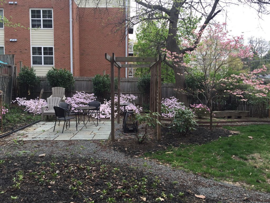 A backyard with a table and chairs in front of a brick building