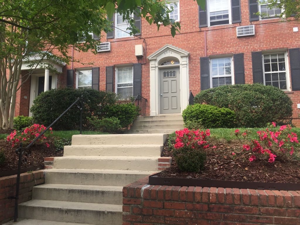 A brick house with stairs leading up to the front door