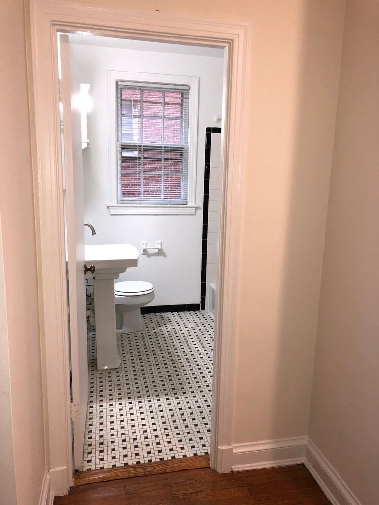 A bathroom with a sink , toilet and window.