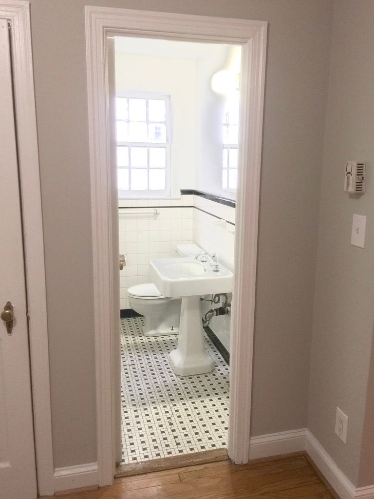 A bathroom with a sink , toilet and window.