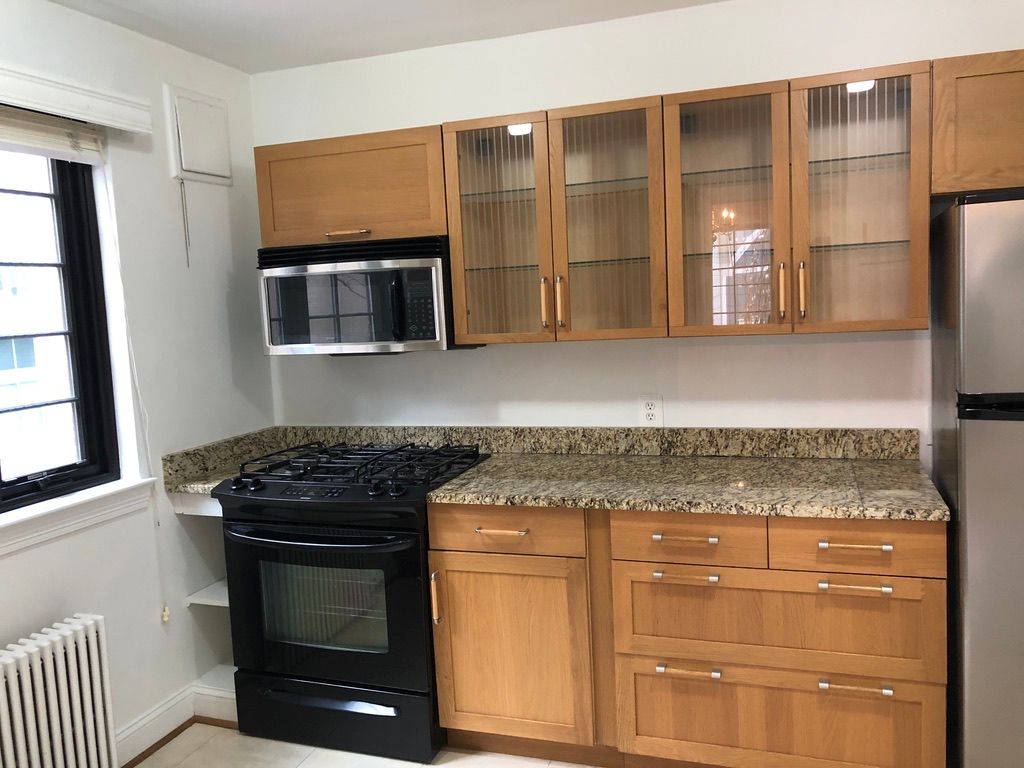 A kitchen with wooden cabinets and stainless steel appliances