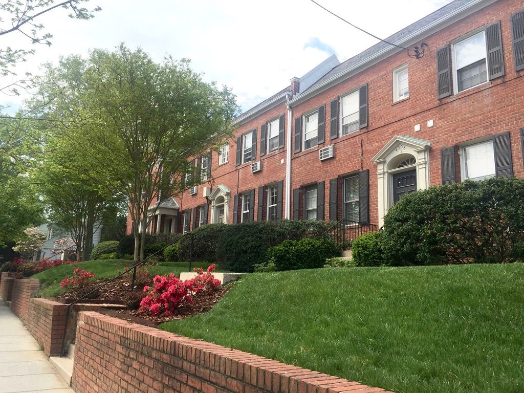 A row of brick houses with a brick wall in front of them