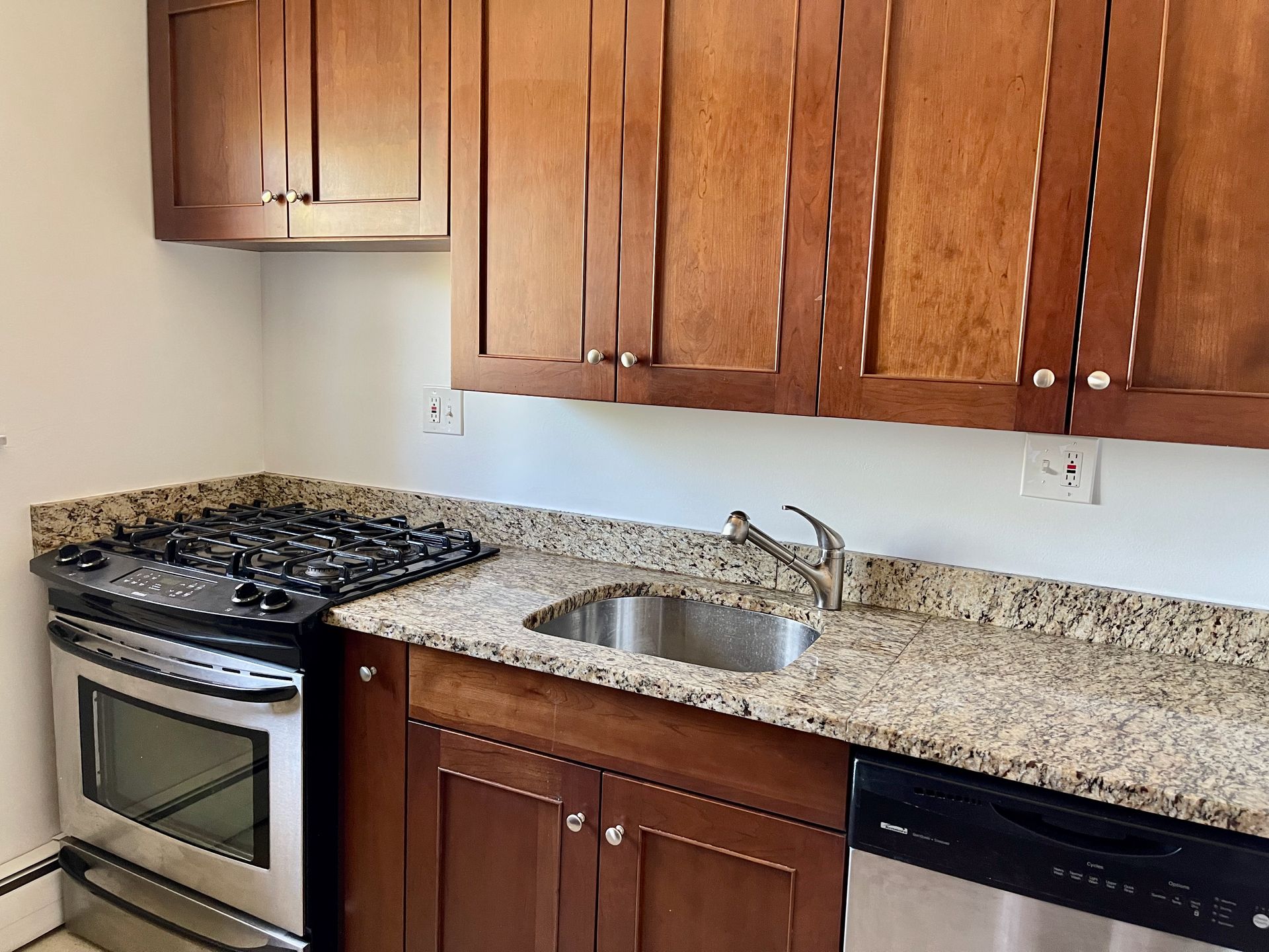 A kitchen with wooden cabinets and granite counter tops