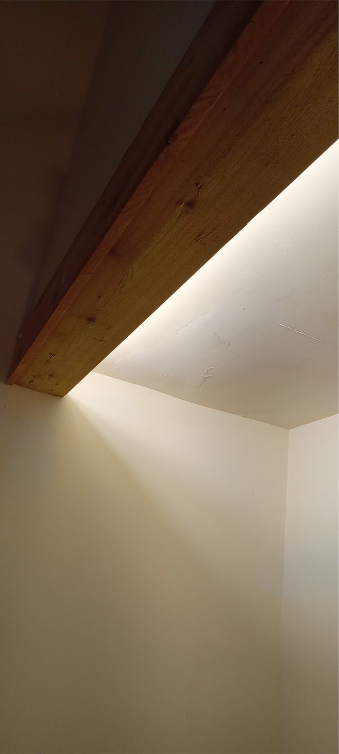 A wooden beam is hanging from the ceiling of a room.