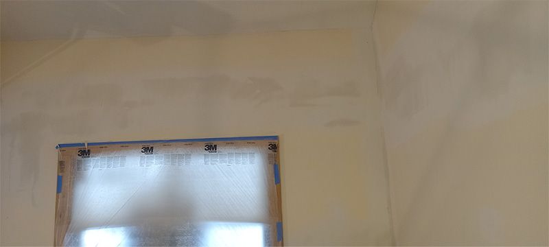 A window is taped to a wall in a room.