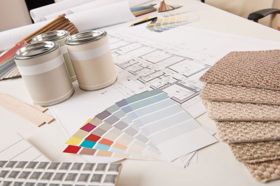 A table with a bunch of samples of carpet and paint on it.