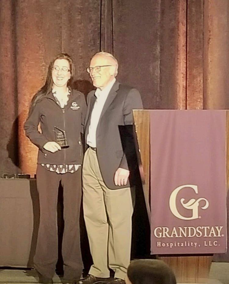 A man and a woman are standing next to each other in front of a podium.
