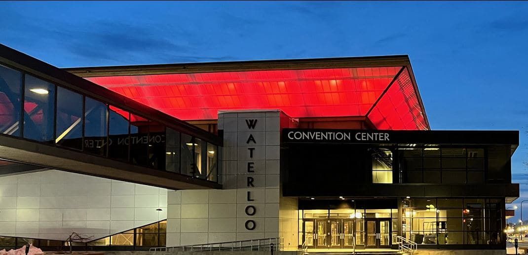 A large building with a red roof is lit up at night.