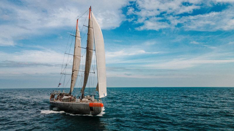 A sailboat is floating on top of a large body of water.