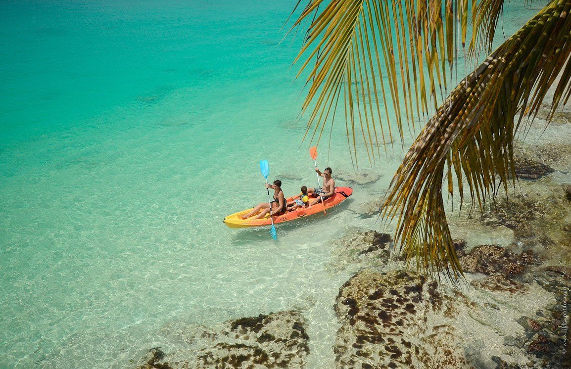A family kayaking by the shore of Pinel island