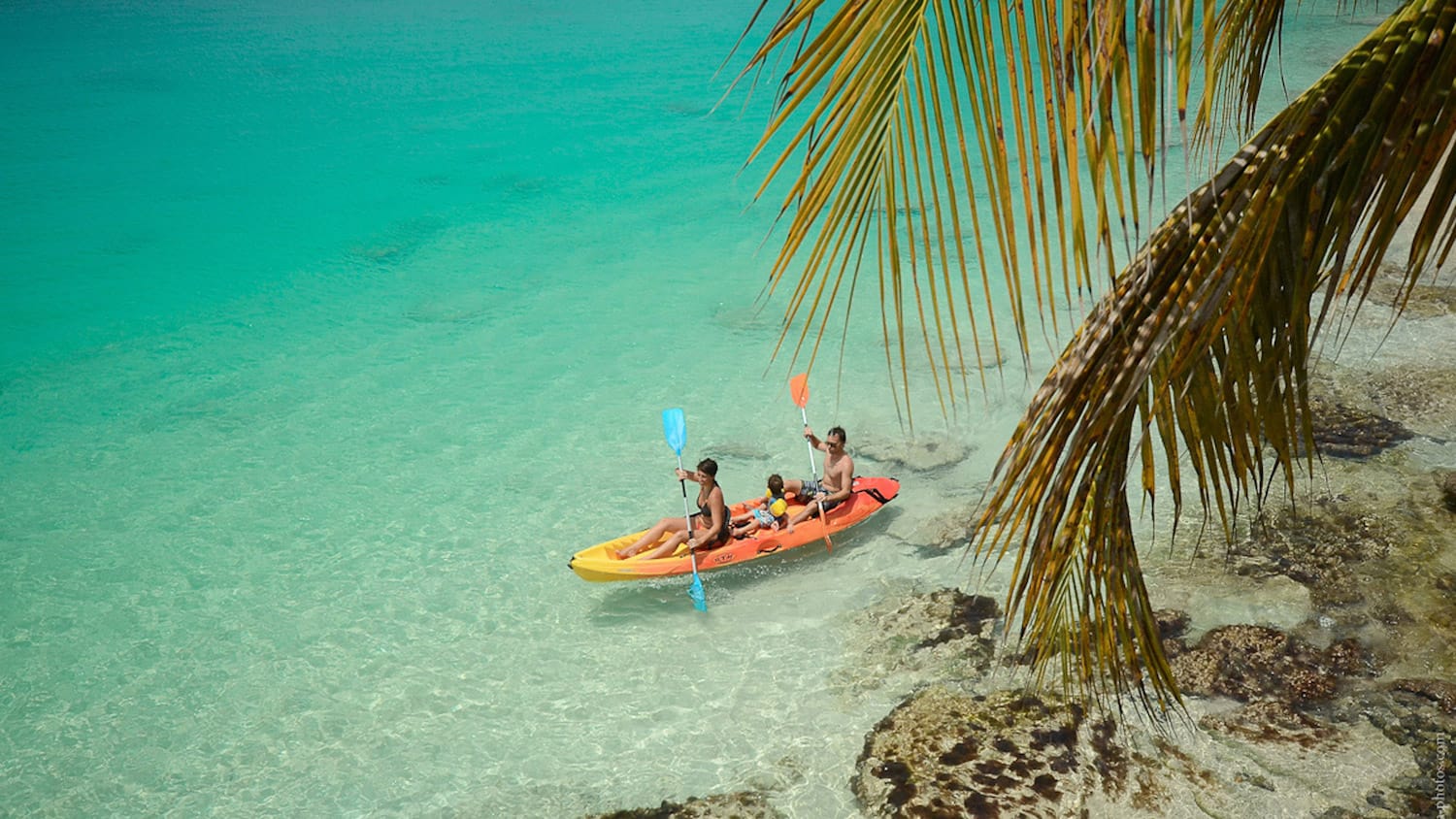 A group of people are in a kayak in the ocean.