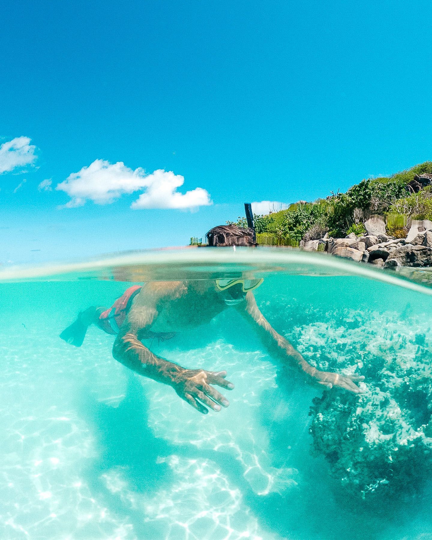 A man is swimming in the ocean with a mask on.