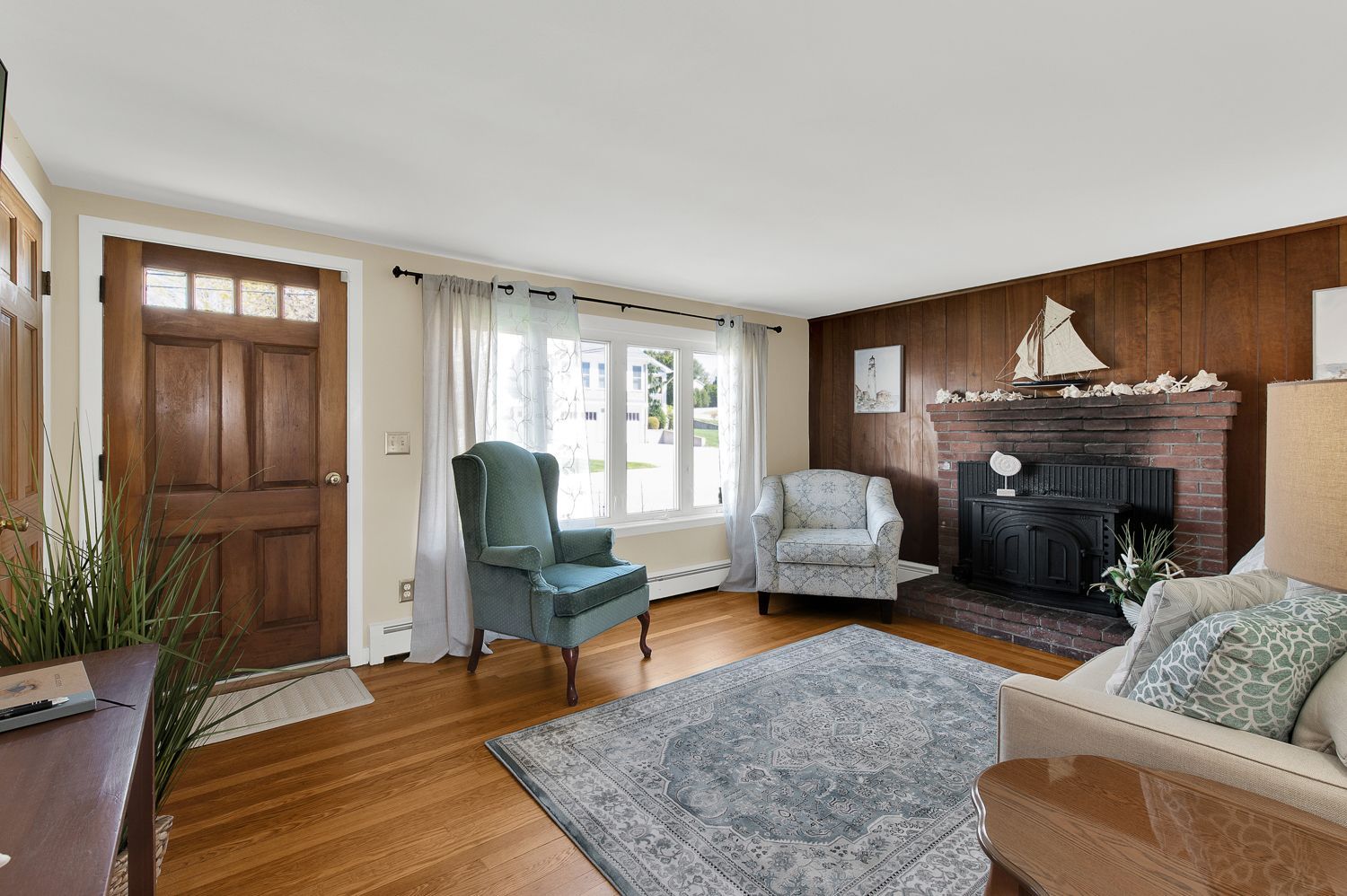 A living room with a fireplace , couch , chair and rug.