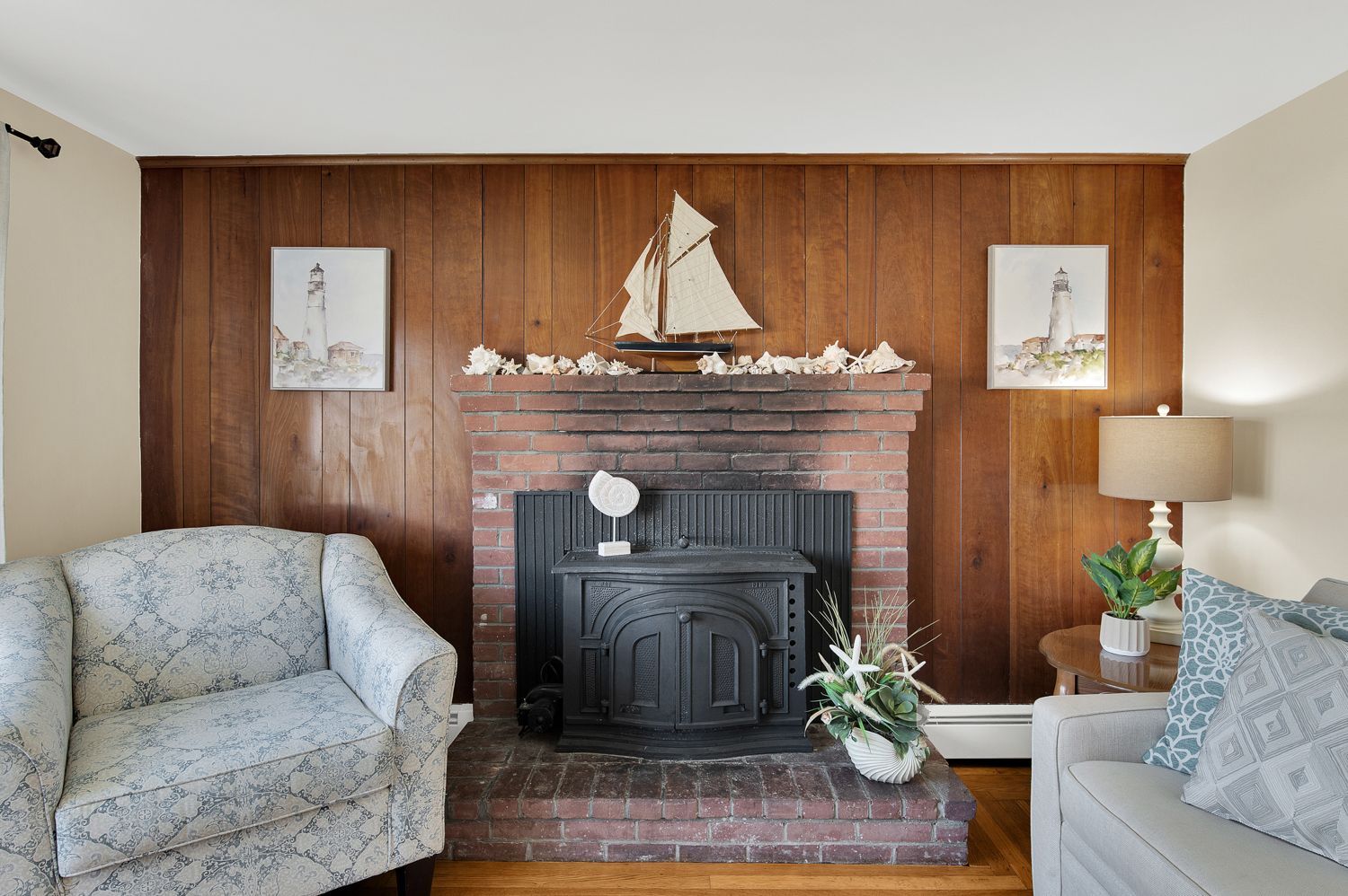 A living room with a fireplace and a sailboat on the mantle