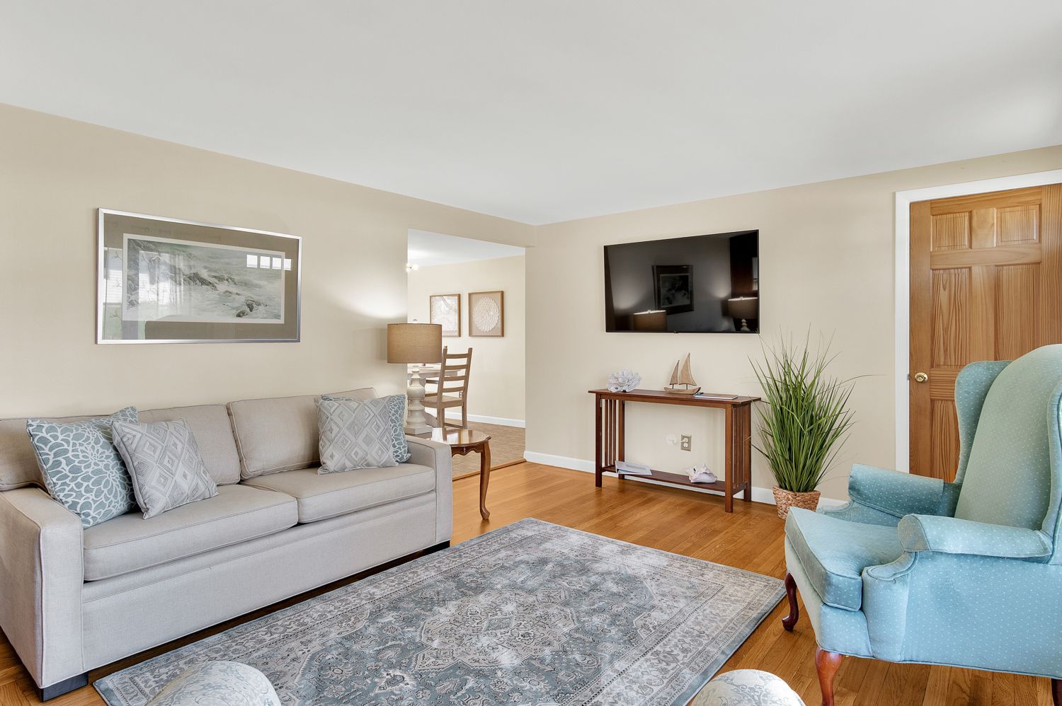 A living room with a couch , chair , and television.