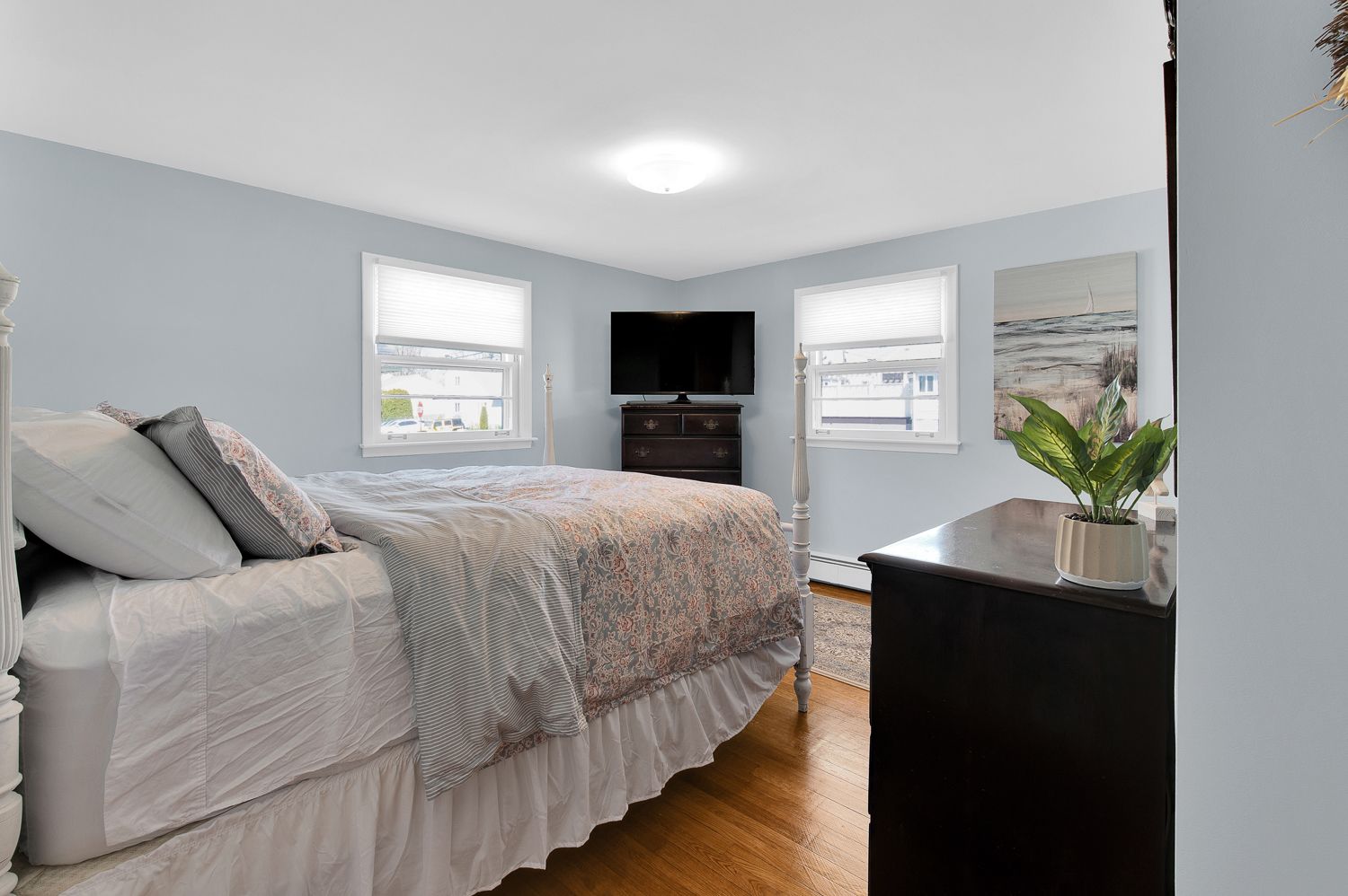 A bedroom with a bed , dresser , and television.