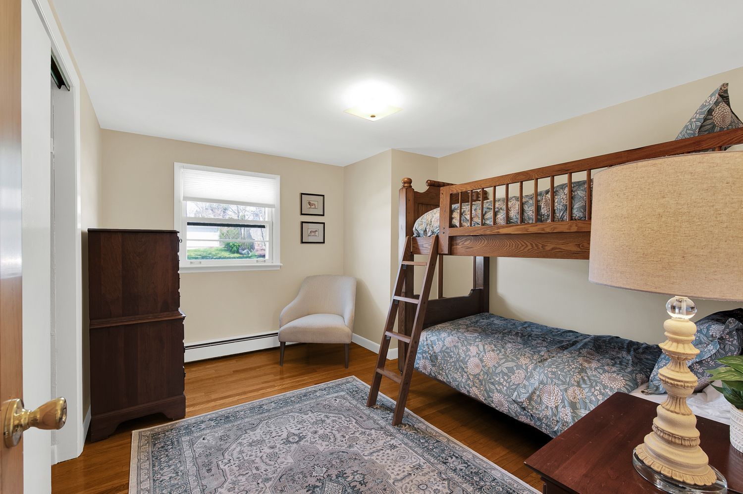 A bedroom with two bunk beds and a lamp.