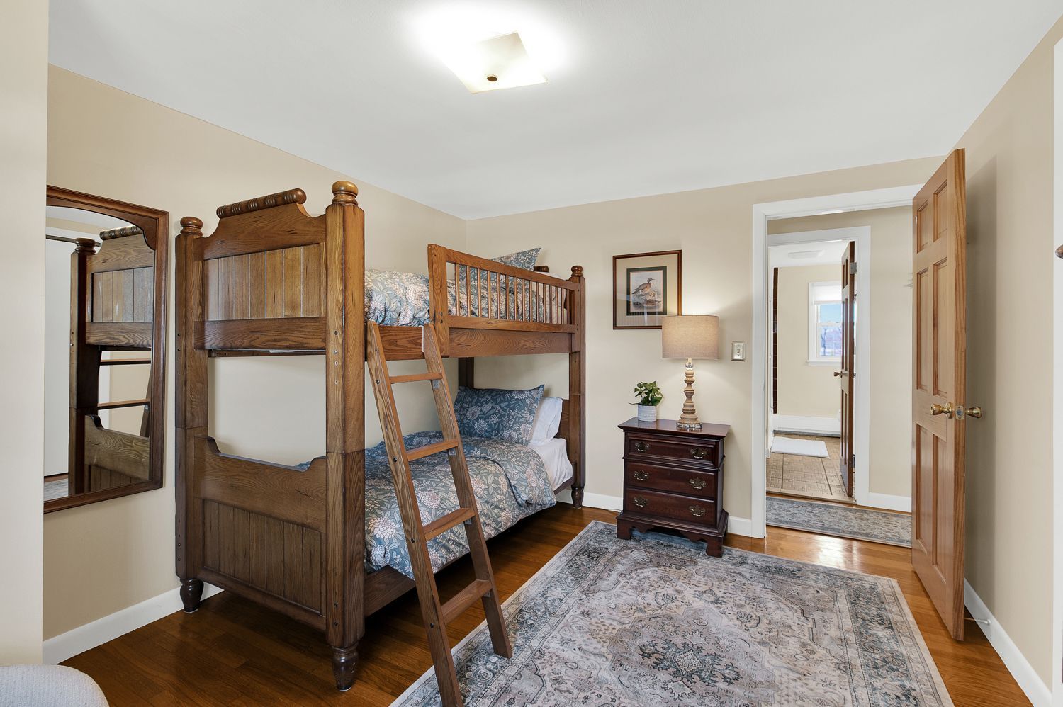 A bedroom with two bunk beds and a nightstand.