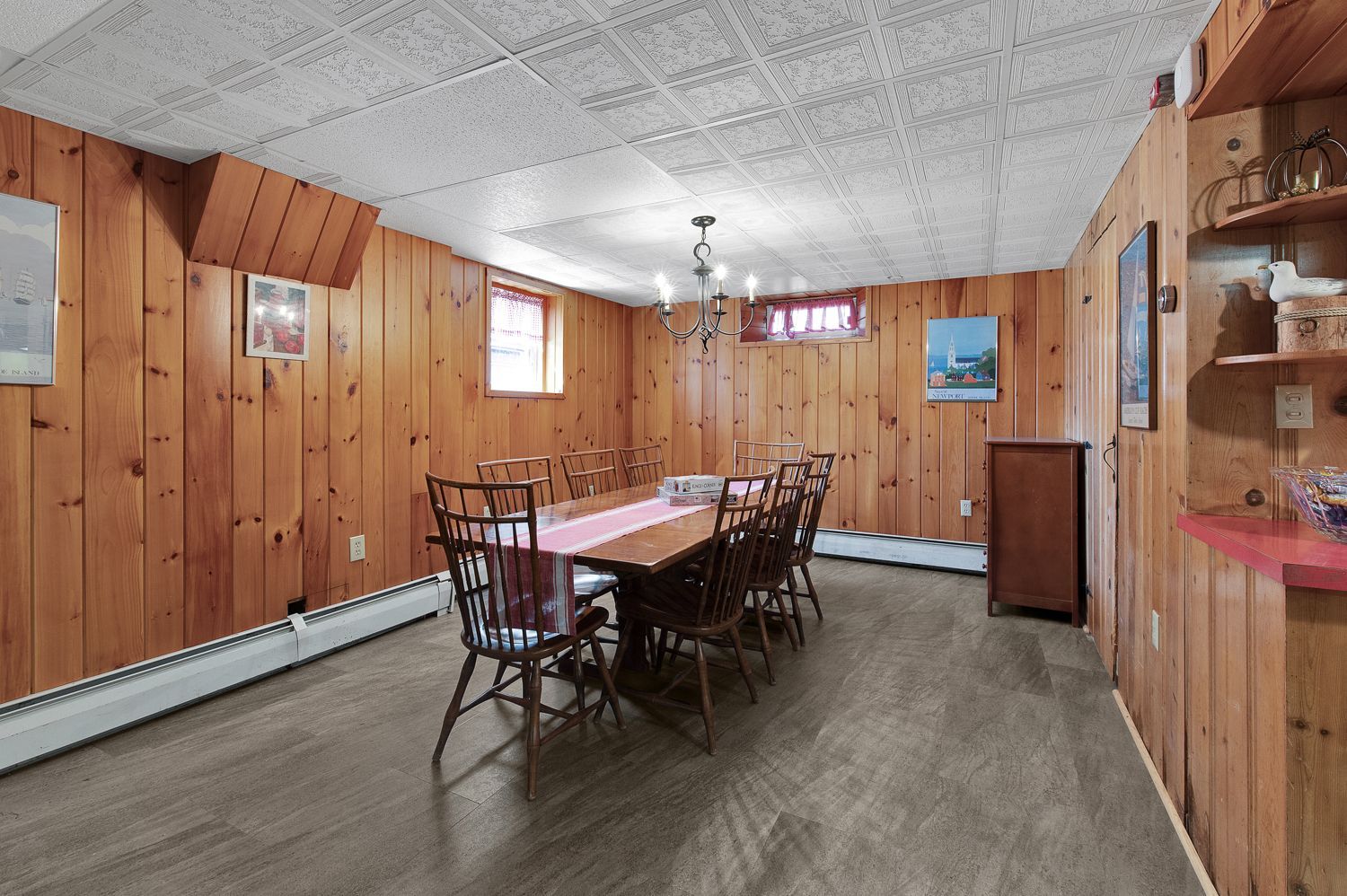 A dining room with wood paneling and a table and chairs