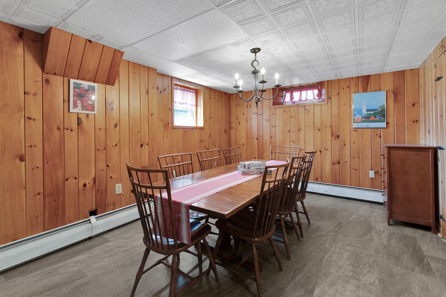 A dining room with a long wooden table and chairs.
