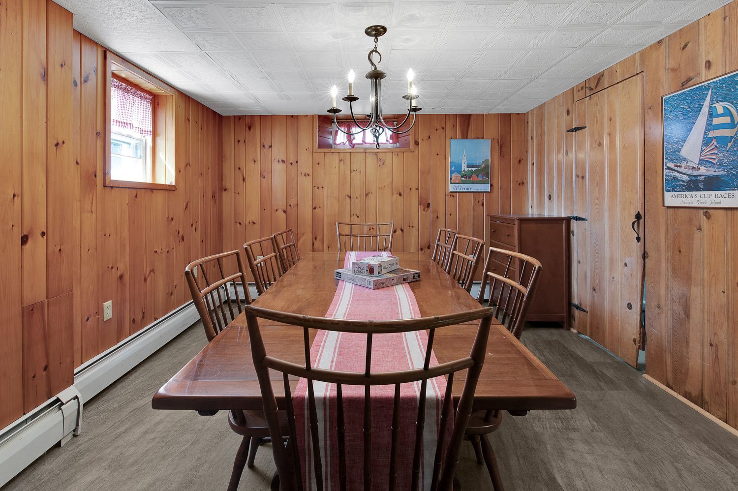 A dining room with a long wooden table and chairs.
