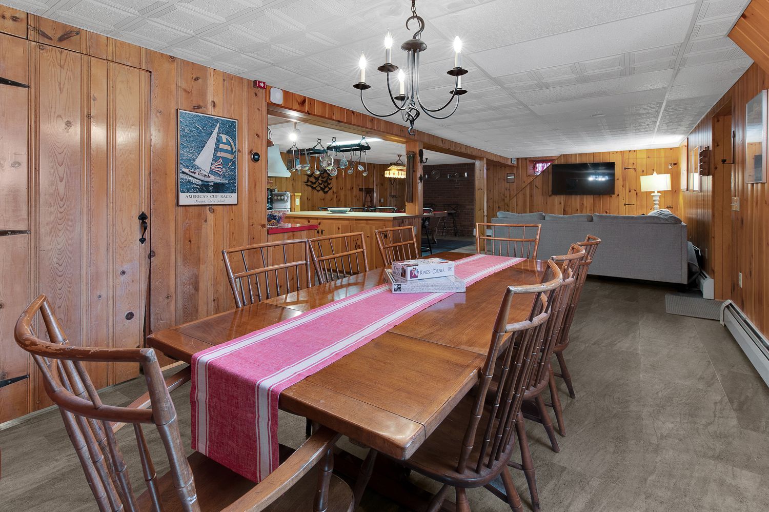 A dining room with a long wooden table and chairs.
