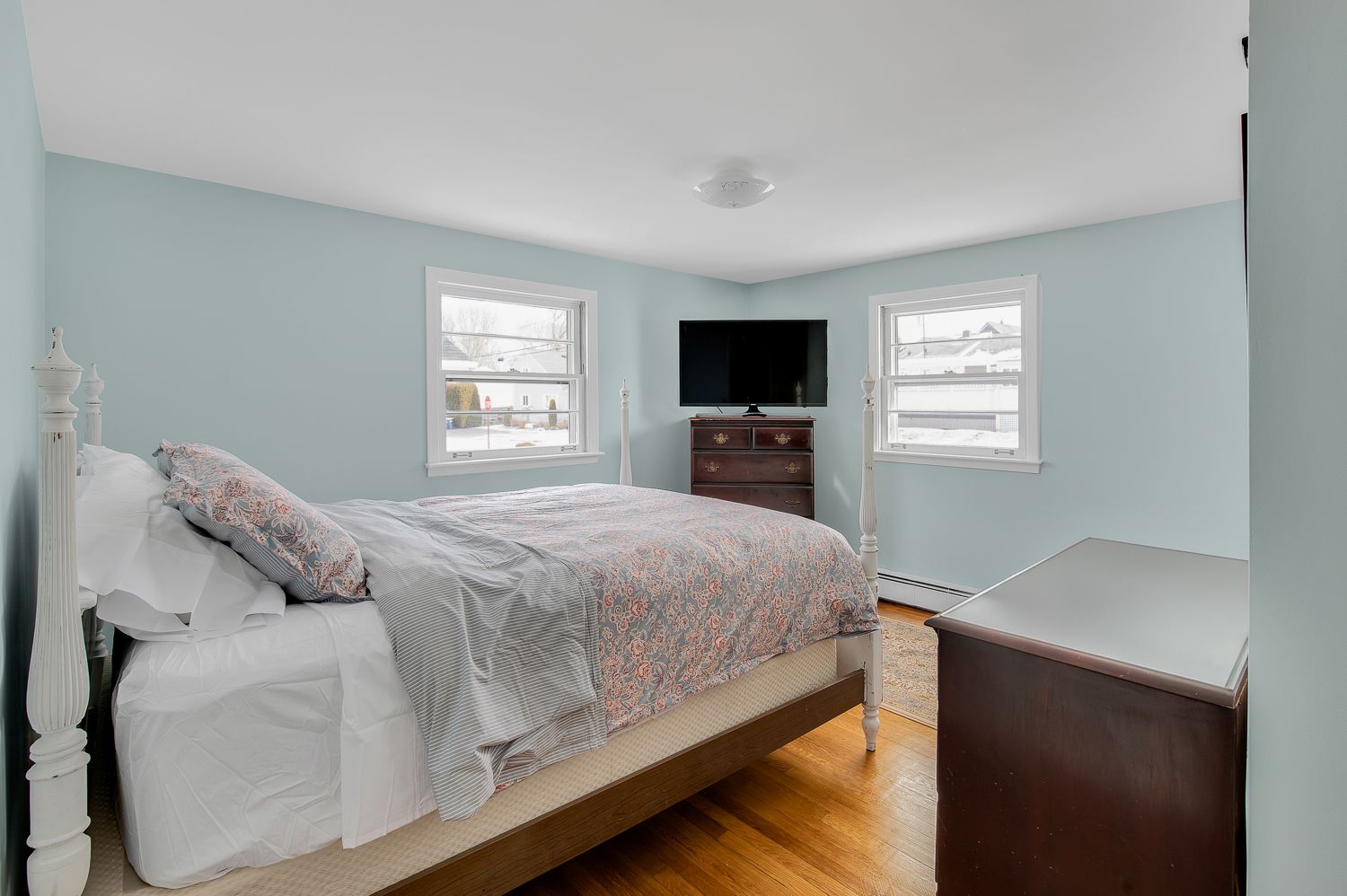 A bedroom with a bed , dresser , and television.