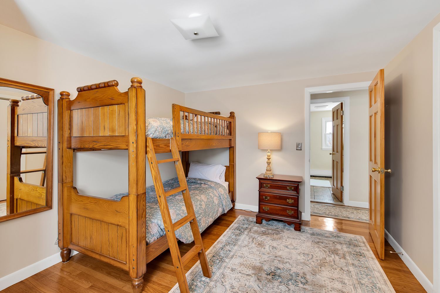 A bedroom with two bunk beds and a nightstand.