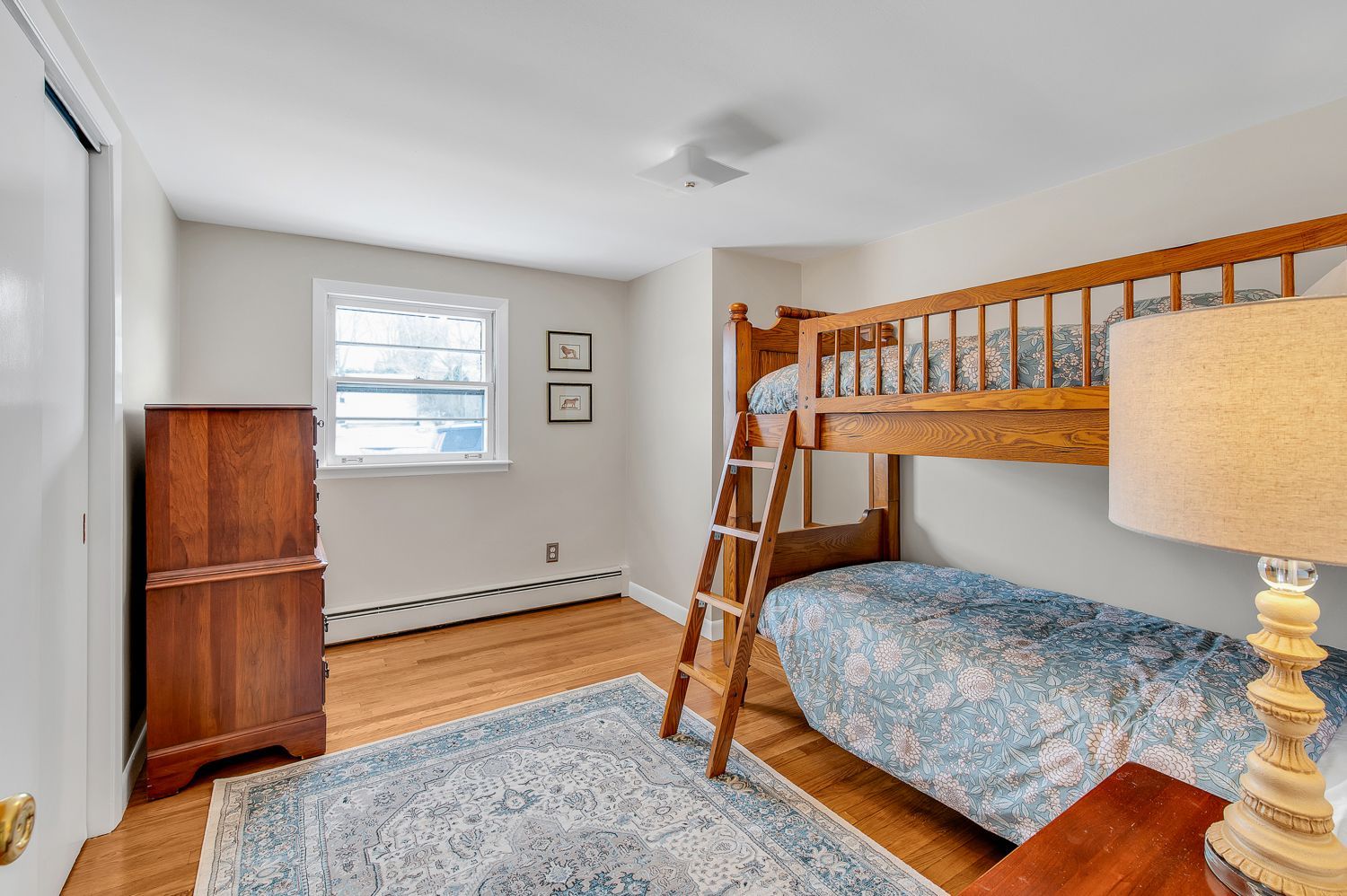 A bedroom with two bunk beds and a lamp.