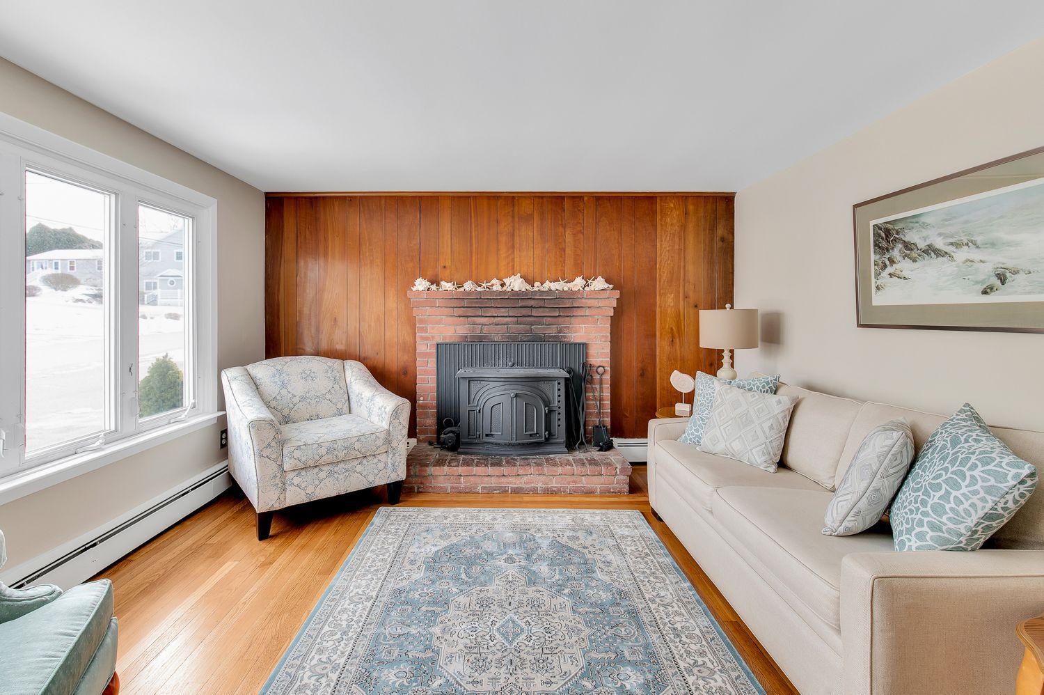 A living room with a fireplace , couch , chair and rug.