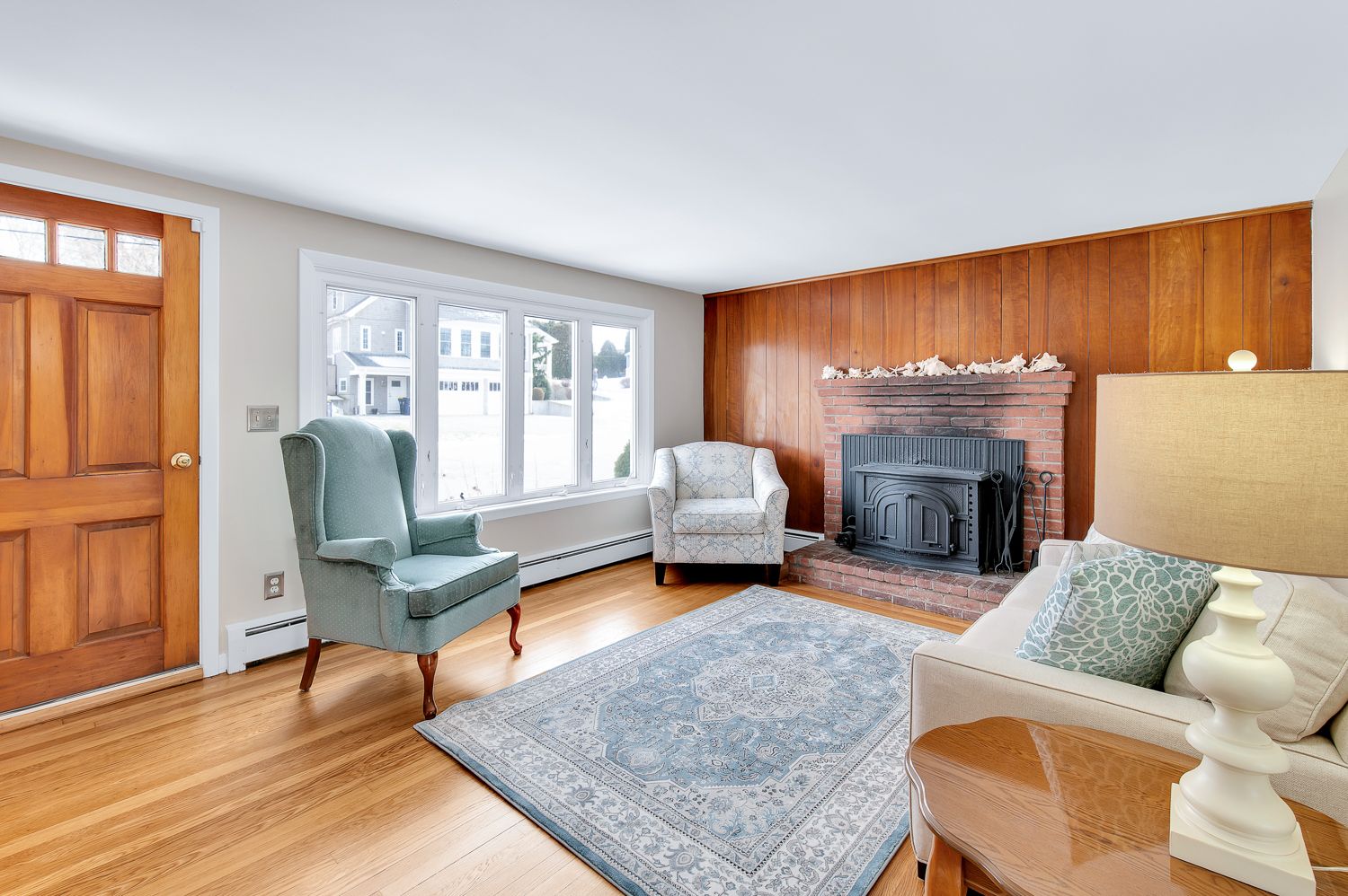A living room with a couch , chairs , rug and fireplace.
