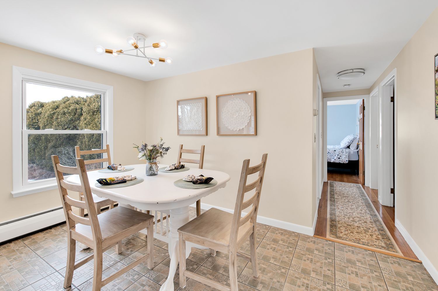 A dining room with a table and chairs and a window.