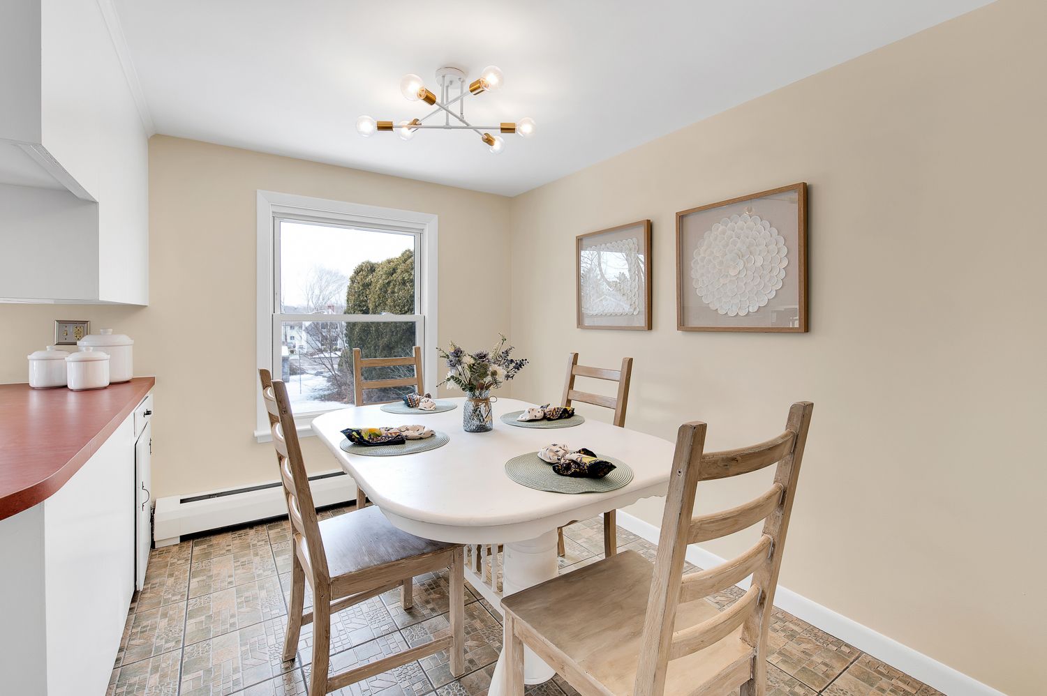 A dining room with a table and chairs and a window.