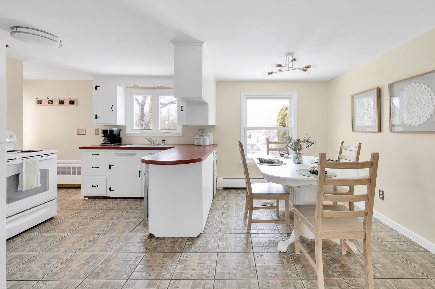 A kitchen and dining room in a house with a table and chairs.