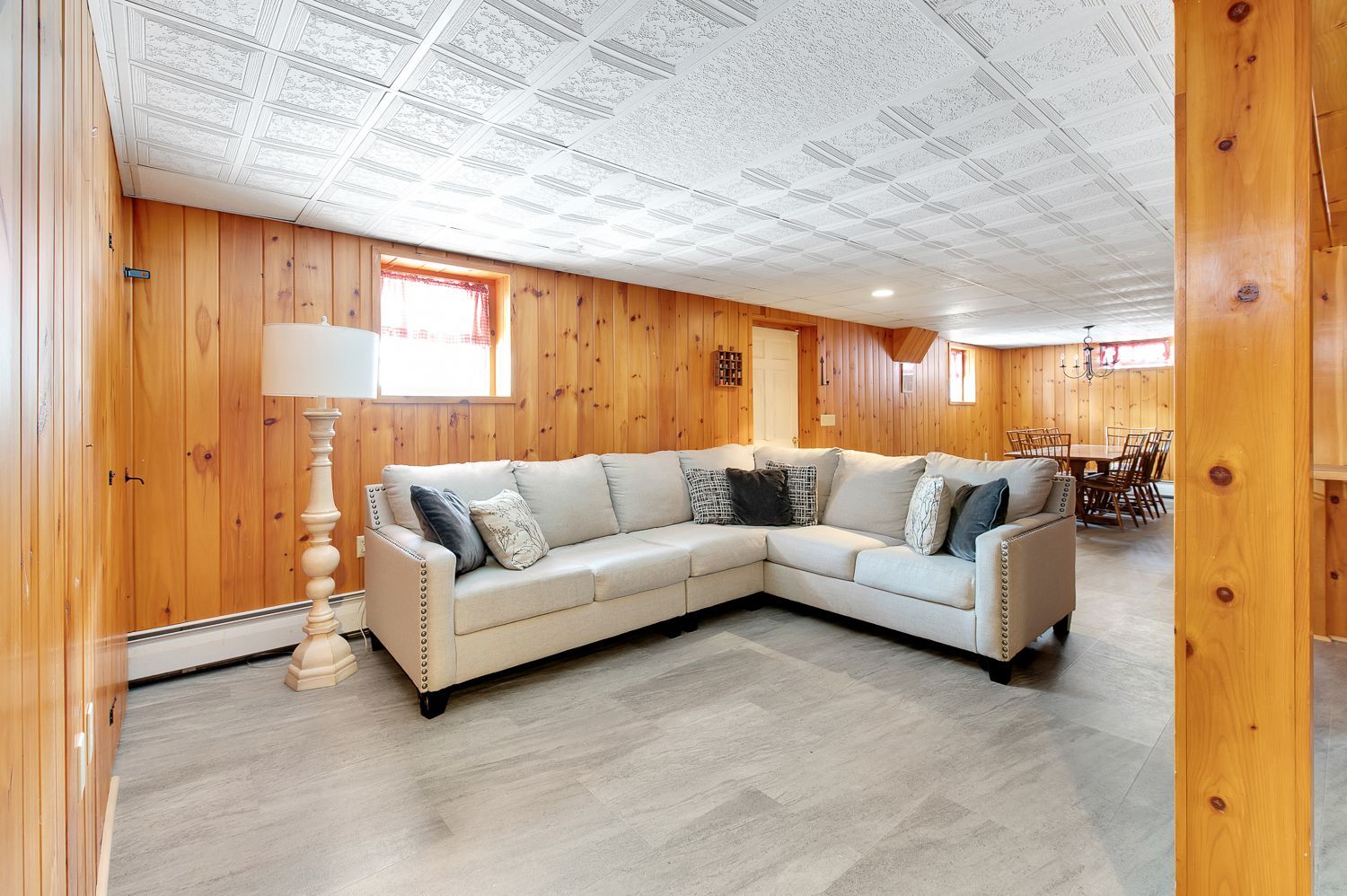 A living room with a large sectional couch and a lamp.