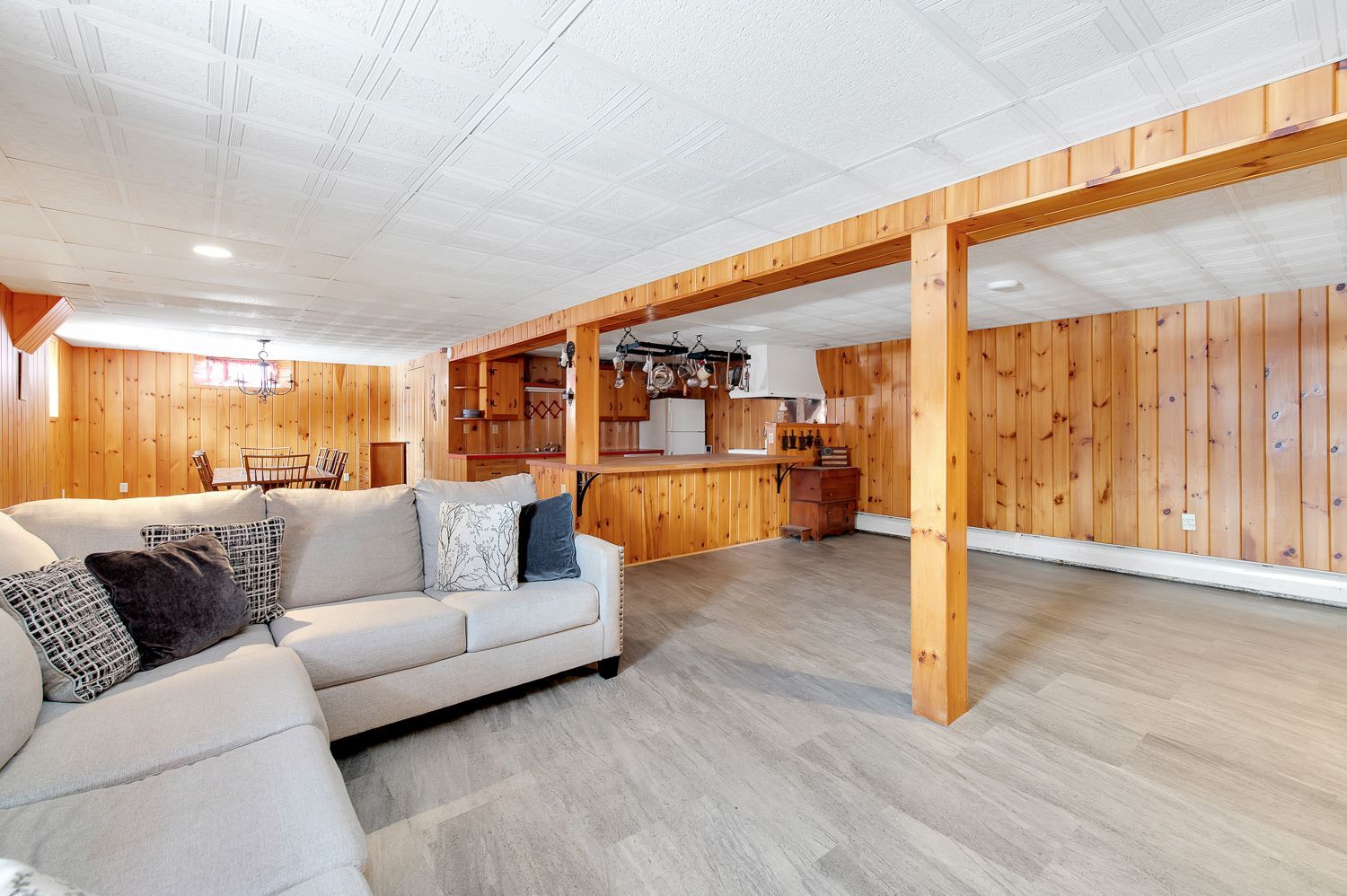 A living room with a couch and wooden walls.
