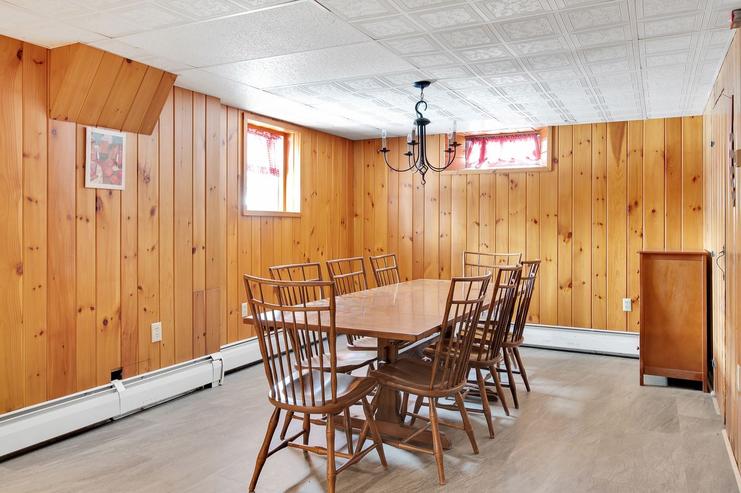 A dining room with wood paneling and a table and chairs