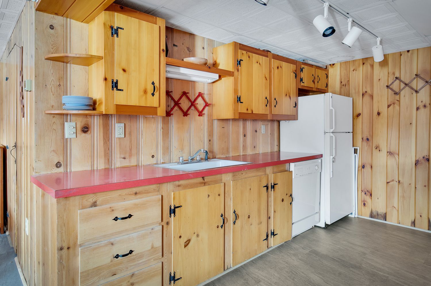 A kitchen with wooden cabinets and a white refrigerator