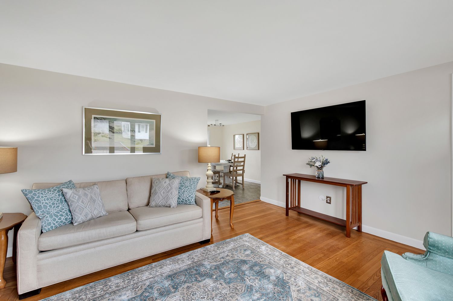 A living room with a couch and a flat screen tv on the wall.