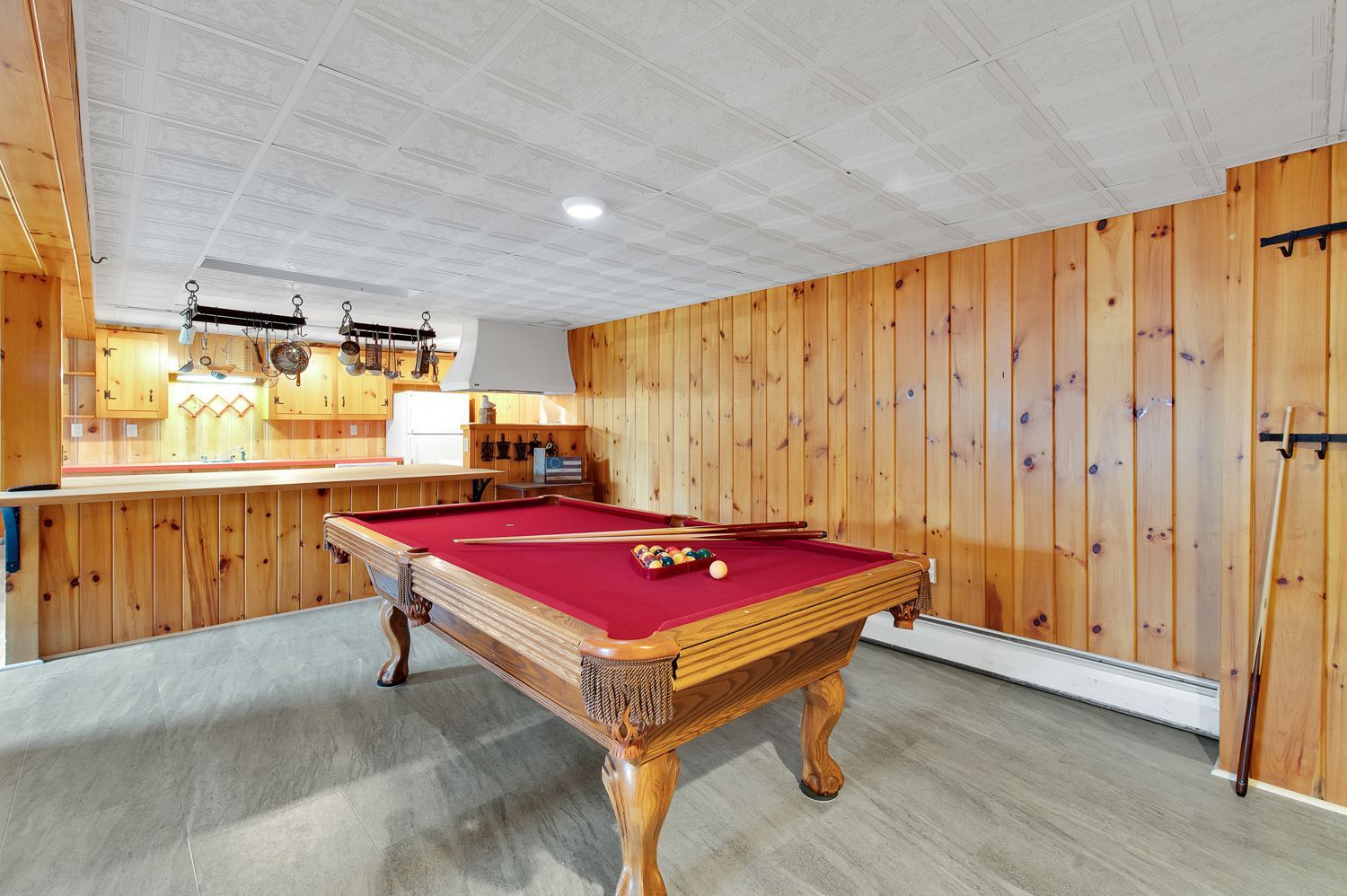 A pool table in a room with wood paneling