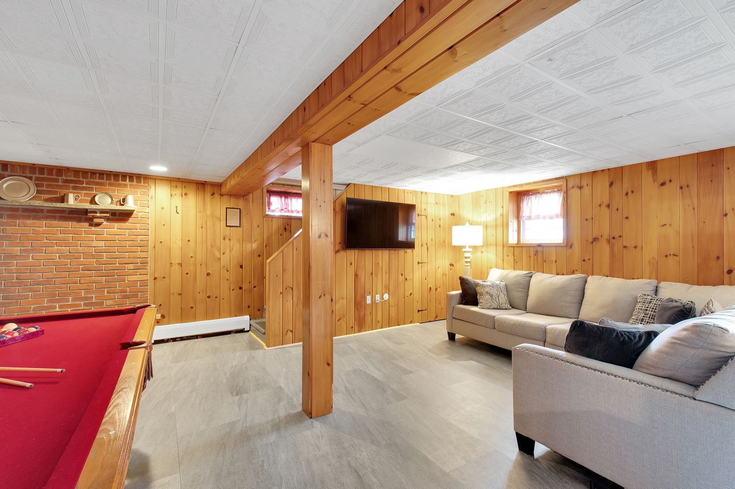 A living room with a pool table and a couch