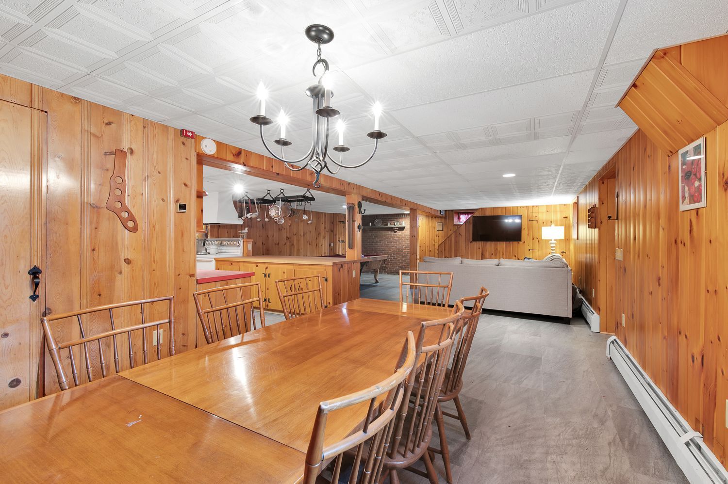 There is a large wooden table and chairs in the middle of the room.