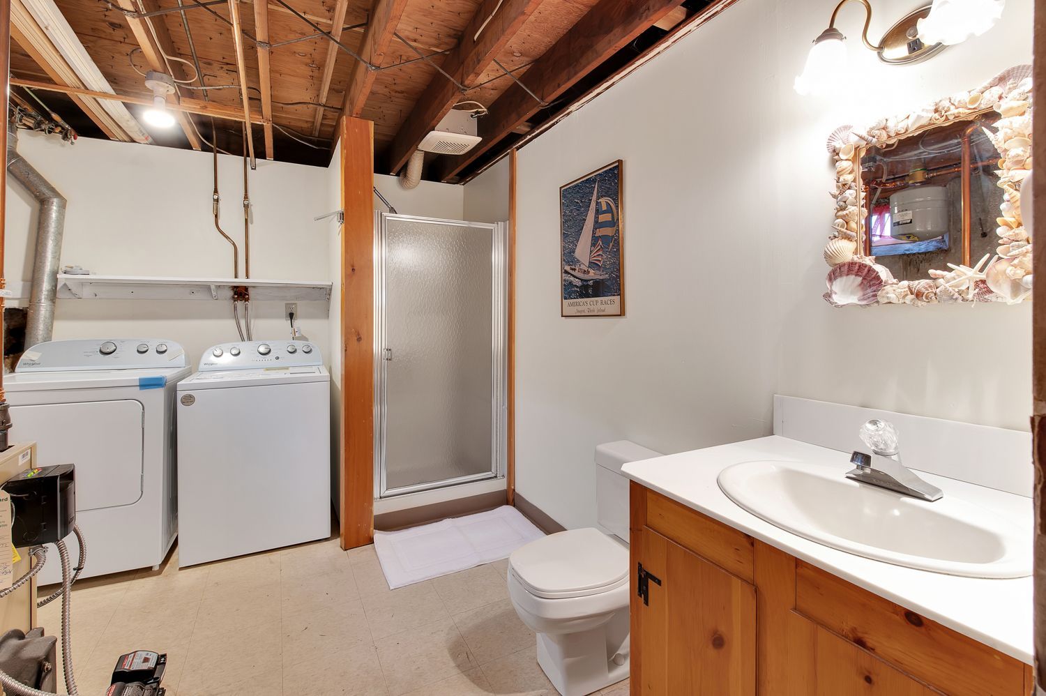 A bathroom with a sink , toilet , washer and dryer.