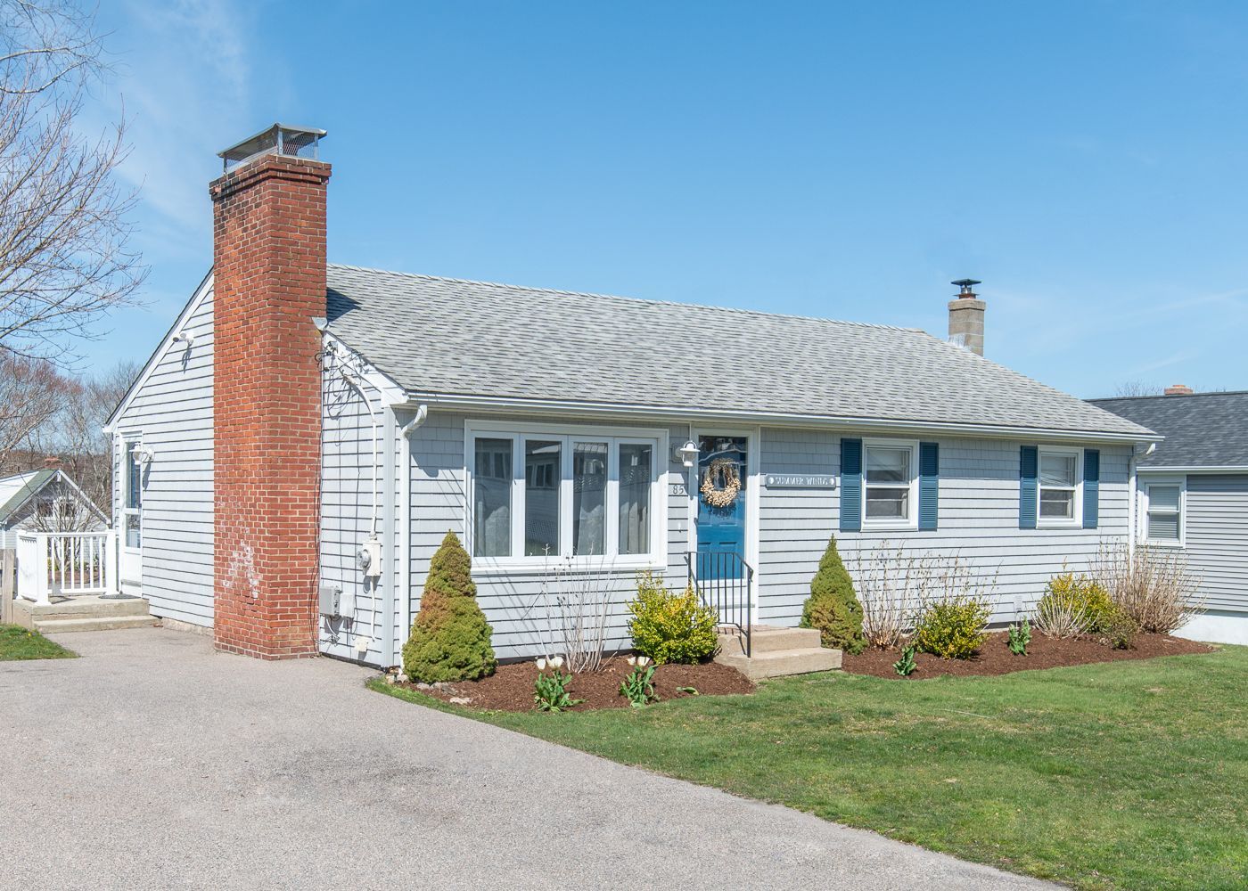 A small house with a brick chimney and a blue door.