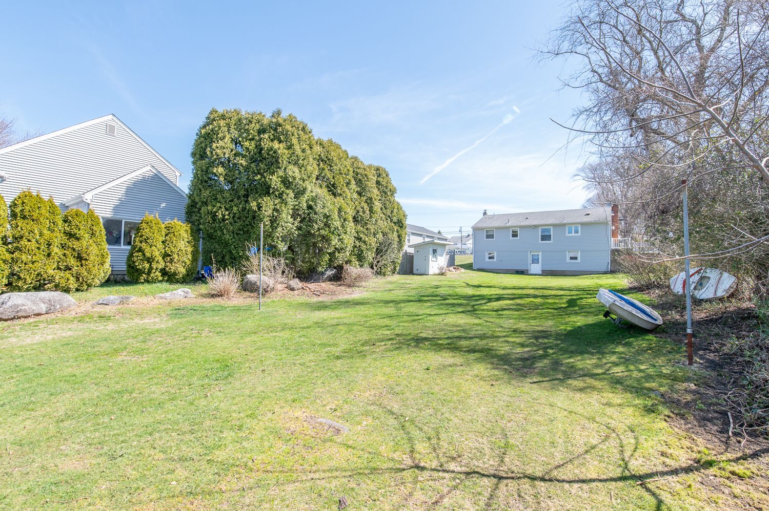 A large grassy field with a house in the background.