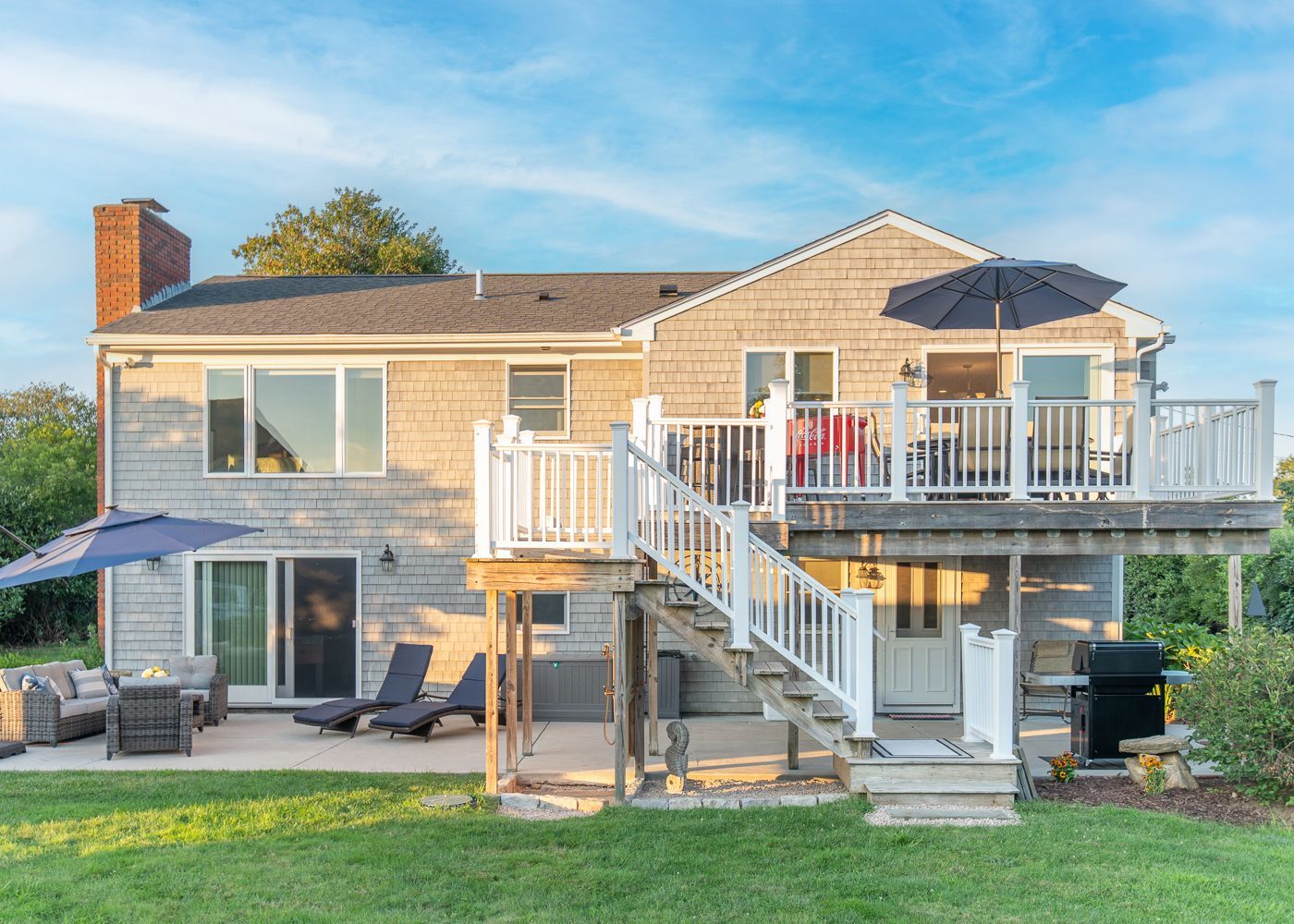The back of a house with a large deck and stairs.